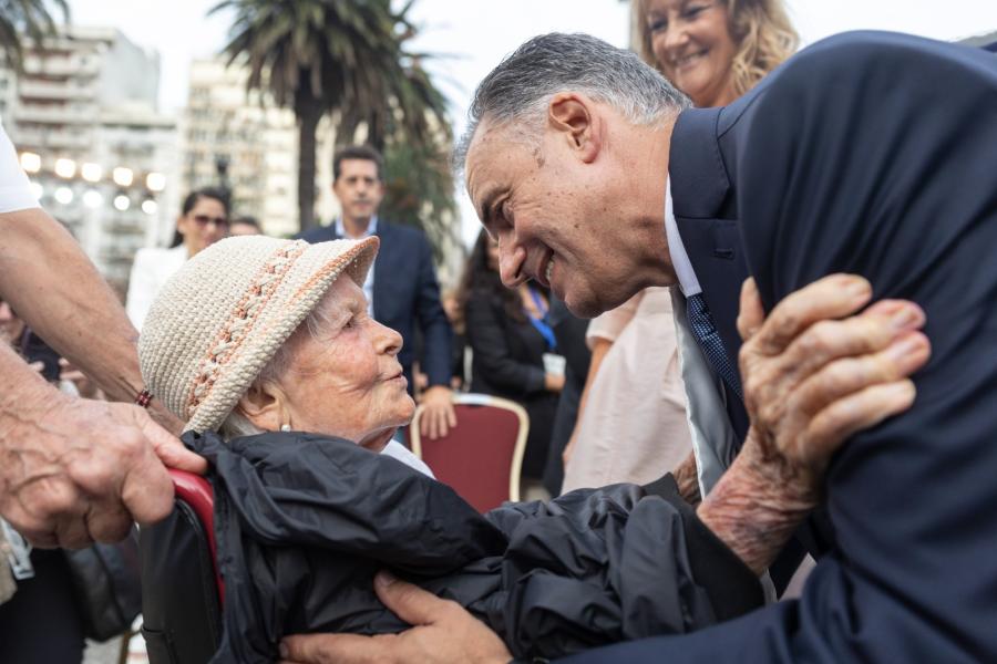 Presidente Yamandú Orsi, de pie, saluda a Belela Herrera, que se encuentra sentada