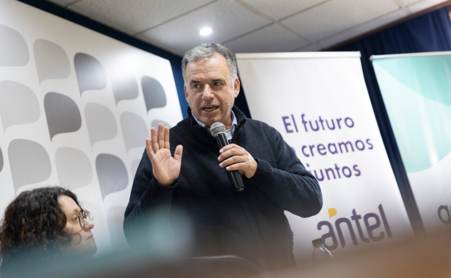 El presidente Yamandú Orsi habla, de pie, sosteniendo un micrófono con su mano izquierda, mostrando la palma de su mano