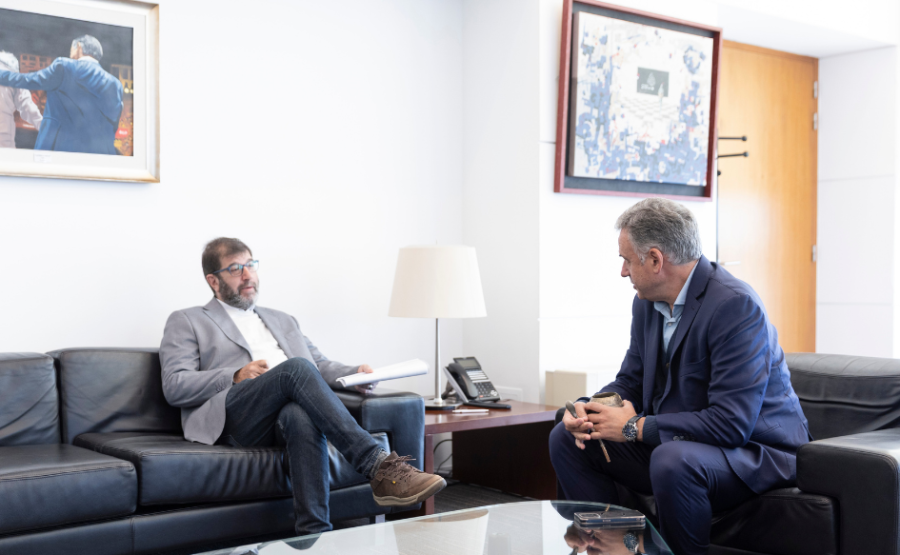 Presidente Yamandú Orsi, sentado en un sillón, dialoga con el presidente del Frente Amplio, Fernando Pereira, en el desp