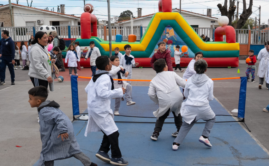 Niños de túnica juegan al fútbol tenis en la plaza de deportes n°10, durante la celebración del Día de la Niñez en Cerro