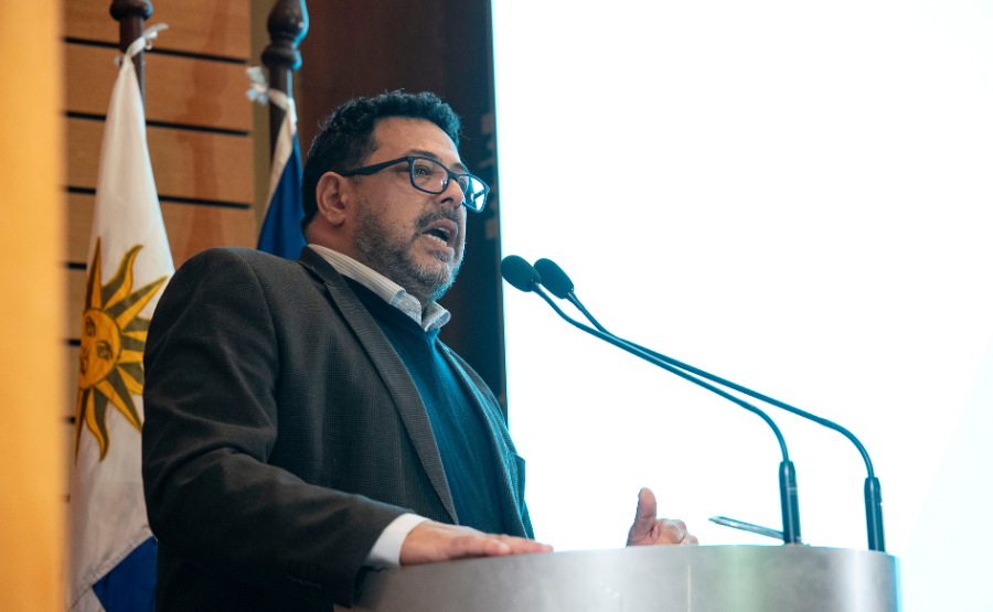 Secretario de Presidencia, Alejandro Sánchez, habla de pie, detrás de un atril, en el auditorio de Torre Ejecutiva. Detr