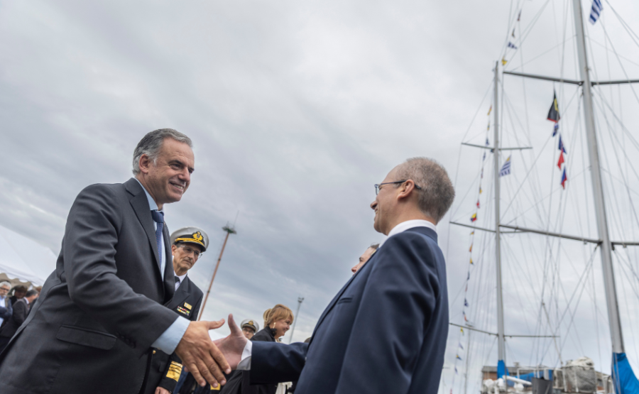 Presidente Yamandú Orsi saluda al comandante del Capitán Miranda. De fondo, el velero.
