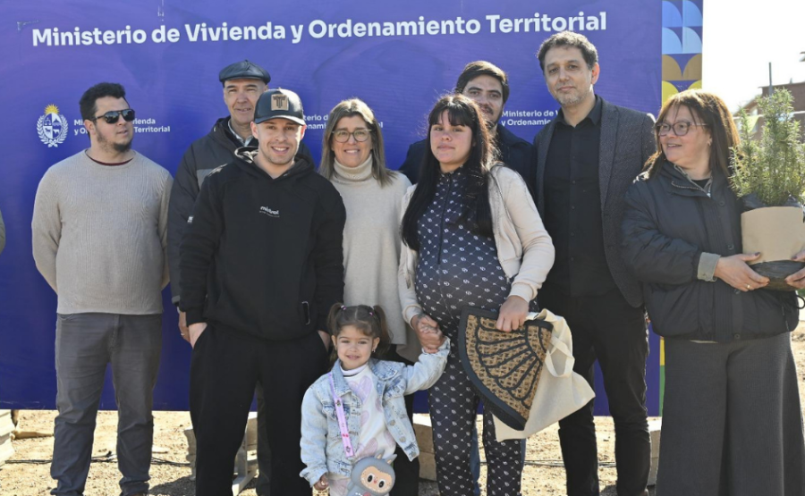 Una familia compuesta por una mujer embarazada, una niña de unos cuatro años y un hombre, miran a la cámara, junto a la 