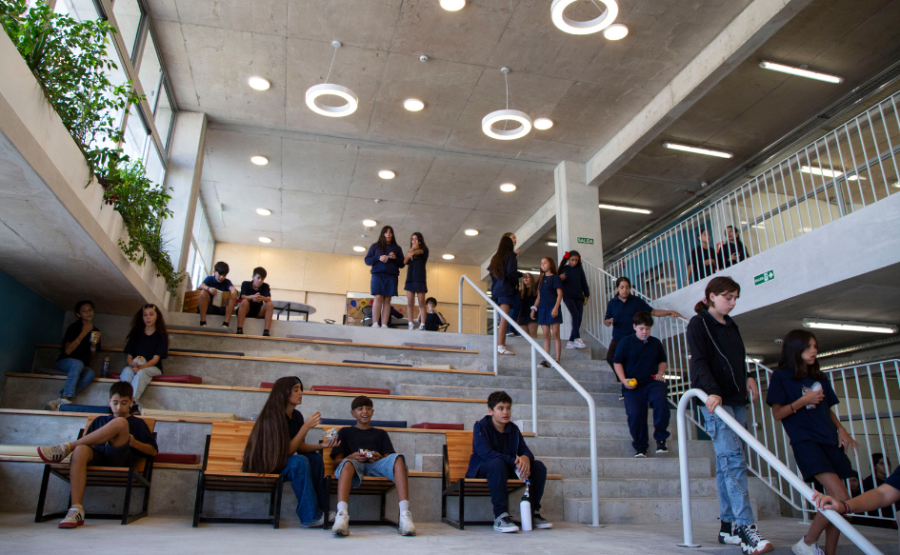 Estudiantes de un liceo sentados en la escalera. Otros, descienden caminando