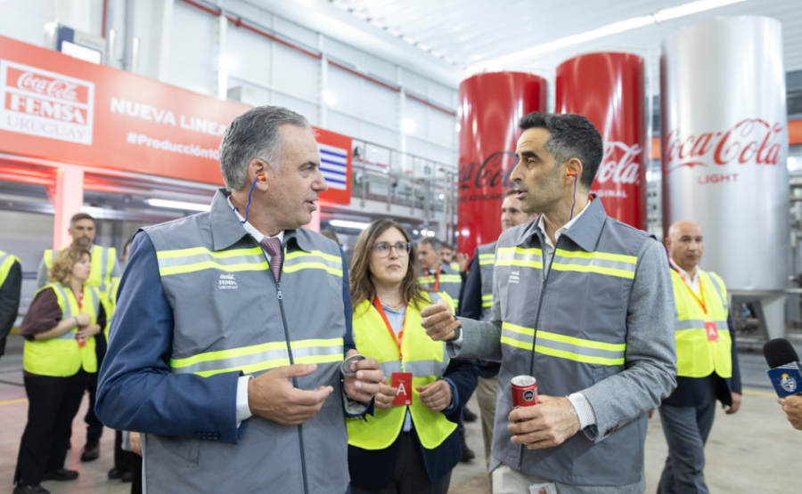 Presidente Yamandú Orsi dialoga con funcionario de Coca Cola Femsa en la línea de producción de latas. En el fondo, dos 