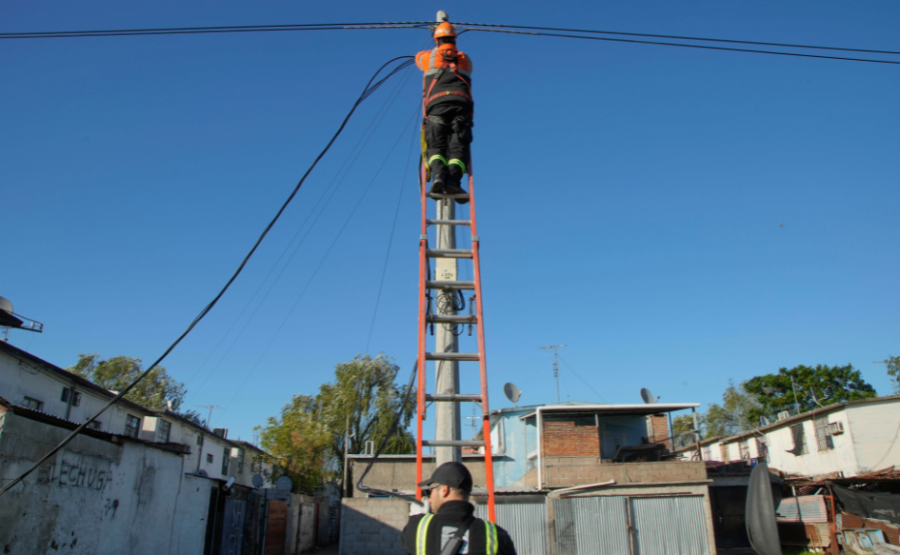Funcionario de la Intendencia de Montevideo, subido a una escalera, manipula el cableado del alumbrado público en Cerro