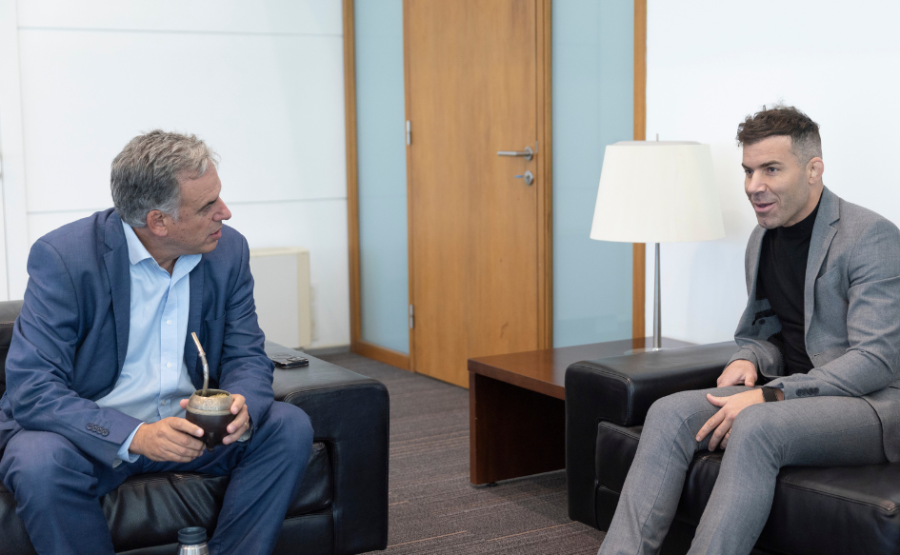 Presidente Orsi sentado en un sillón, con el mate en la mano. En otro sillón está sentado Gastón Reyno