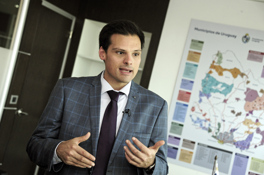 Director de Descentralización, José Manuel Arenas, habla gestualizando con las manos. De fondo, un mapa de Uruguay