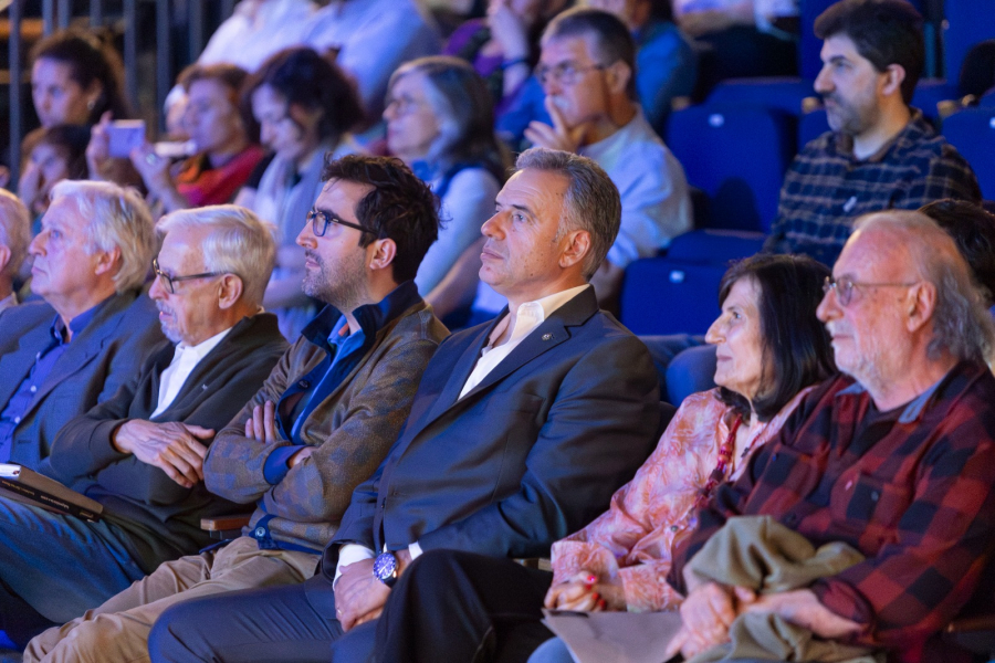 Presidente Yamandú Orsi, sentado en primera fila de la sala Hugo Balzo del Sodre, observa el escenario. A su lado, la au