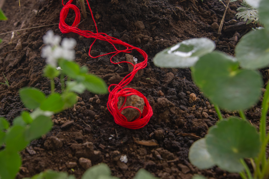 Tierra e hilo rojo que forma parte de la exposición "En ELLA estamos todas"