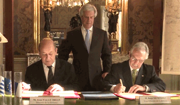 El ministro de Defensa de Francia, Jean Yves Le Drian, firma el acuerdo junto a su par uruguayo, Jorge Menéndez observados por Tabaré Vázquez
