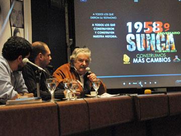 Presidente José Mujica hablando en una mesa con dos personas