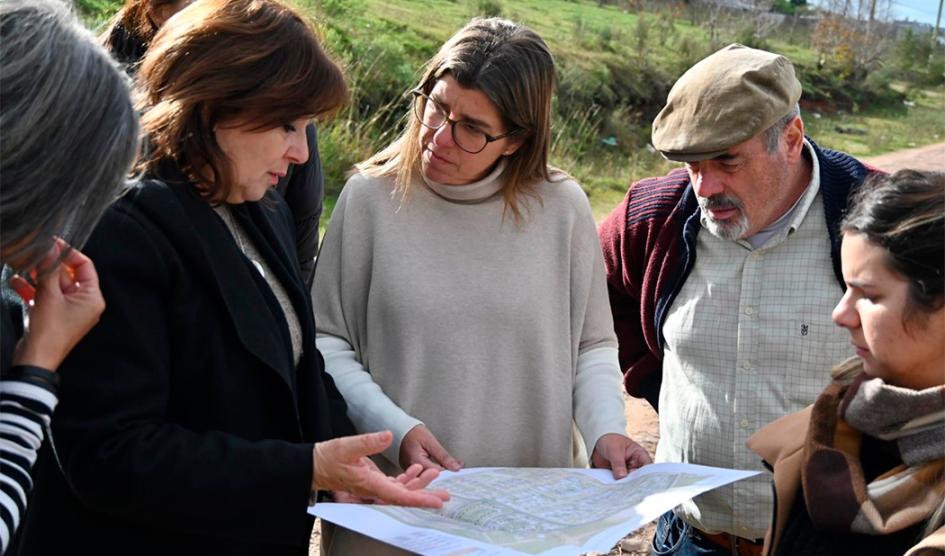 Ministra de Vivienda y Ordenamiento Territorial, Tamara Paseyro, observa planos junto a otras personas