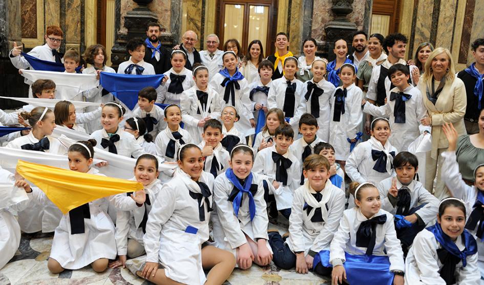 Escolares ataviados con pañuelos de los colores de la bandera nacional posan junto a la vicepresidenta Beatriz Argimón y el ministro de Educación y Cultura, Pablo da Silveira