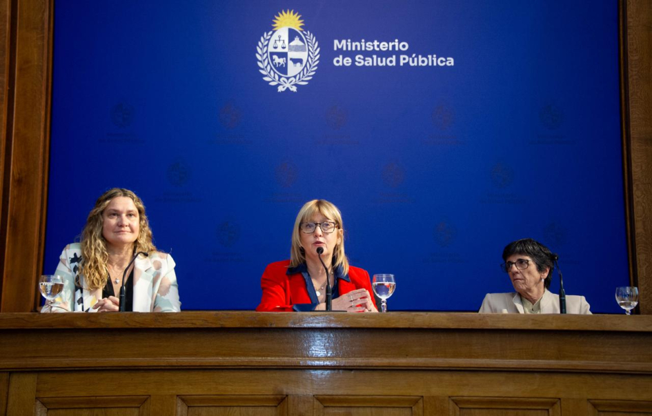 Ministra de Salud, Cristina Lustemberg, habla detrás de micrófono. En el fondo, un banner con el logo del Ministerio de Salud Pública. A su lado, autoridades del Fondo Nacional de Recursos