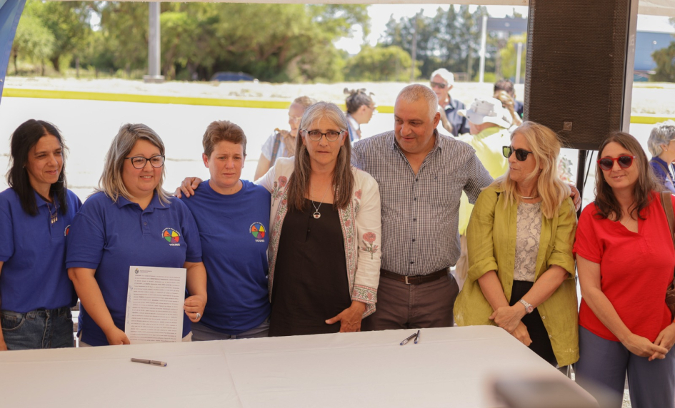 Ministra de Transporte y Obras Públicas, Lucía Etcheverry, de pie, junto a funcionarias del CAIF Los Indiecitos y el director de Arquitectura, Martín Tierno. Una funcionaria sostiene el convenio firmado.
