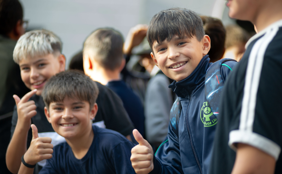 Tres adolescentes, estudiantes del liceo n°23, saludan a la cámara levantando su dedo pulgar