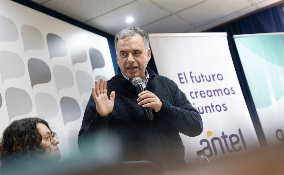 Call center de Antel generará puestos de trabajo en Treinta y Tres El presidente Yamandú Orsi habla, de pie, sosteniendo un micrófono con su mano izquierda, mostrando la palma de su mano derecha. Detrás, un banner con el logo de Antel y la leyenda "El futuro lo creamos juntos"