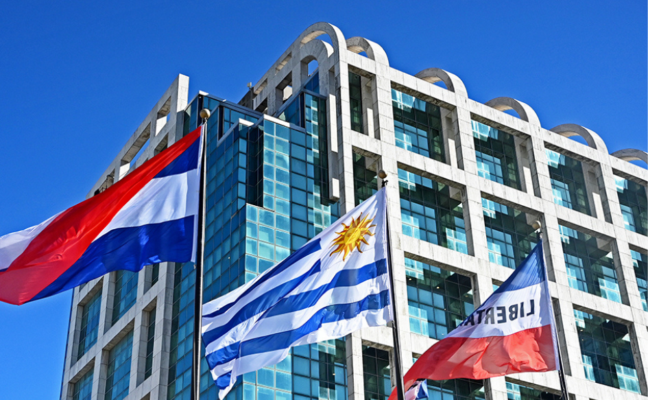 Pabellones patrios en primer plano con la Torre Ejecutiva de fondo