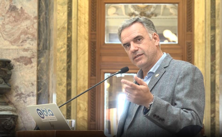 Presidente Yamandú Orsi brinda un discurso detrás de un atril durante la sesión anual del Plenario de Municipios, en el Salón de los Pasos Perdidos del Palacio Legislativo