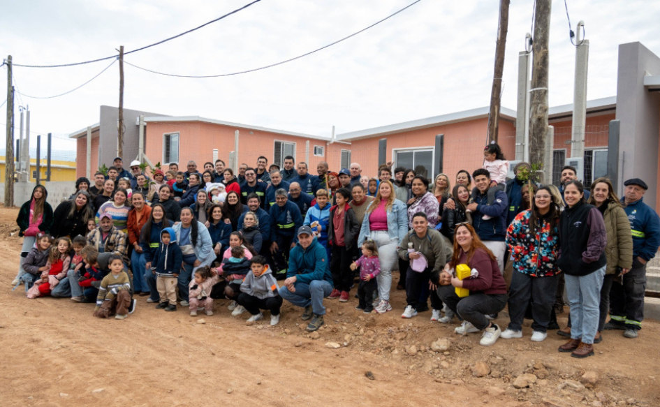 Familias de Melo y funcionarios del Ministerio de Vivienda se toman una foto de familia frente a una de las viviendas entregadas por el Plan Juntos en la capital de Cerro Largo