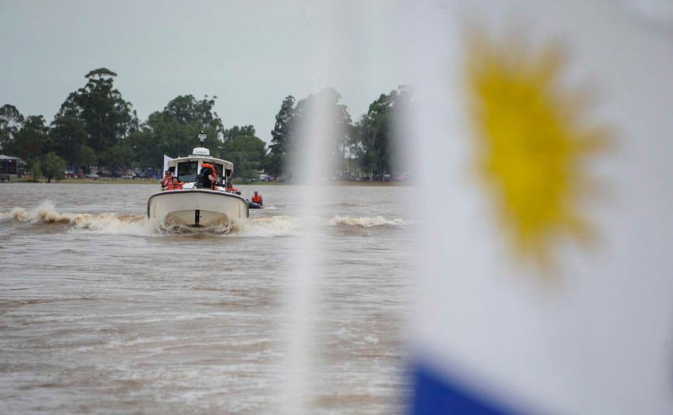 Lancha circula por el río Uruguay. De frente, una parte del pabellón nacional