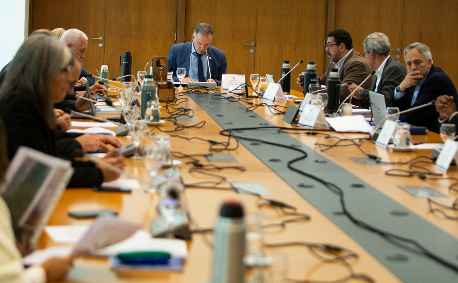 Presidente Yamandú Orsi, sentado en la cabecera de la mesa, lee un documento. A su alrededor, el secretario de Presidencia, Alejandro Sánchez; el prosecretario Jorge Díaz, y el resto del gabinete