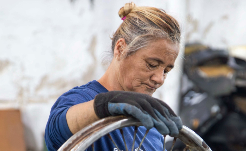 Ejecutivo enviará proyecto de ley que crea causal de retiro anticipado a partir de los 60 años Mujer de unos 60 años con uniforme de trabajo manipula una rueda