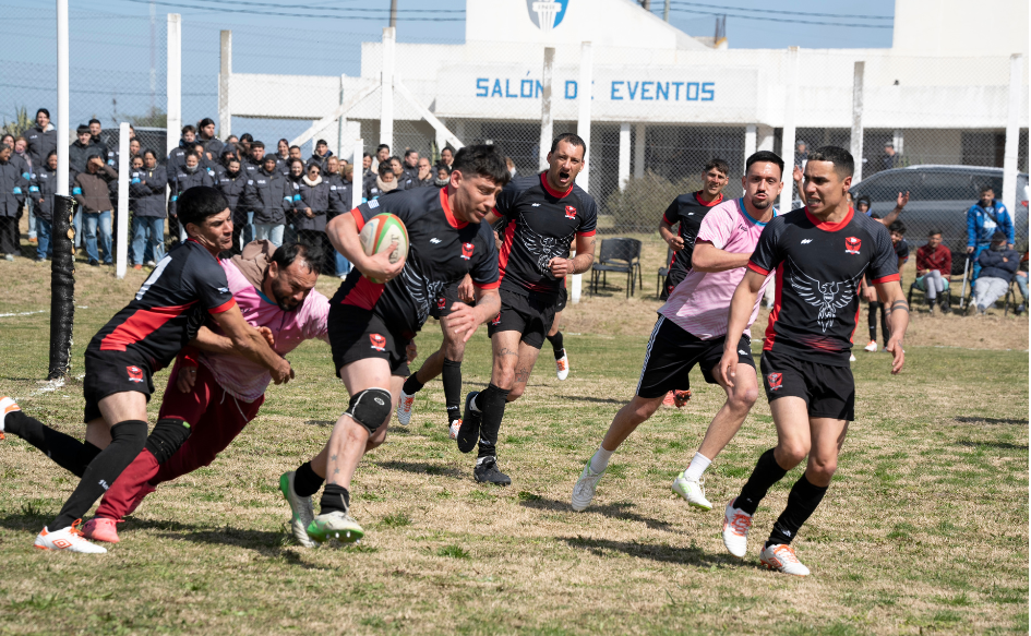 Personas privadas de libertad juegan al rugby en la cancha de la unidad n°4 del INR, durante la celebración del 10° aniversario del programa de rugby en cá