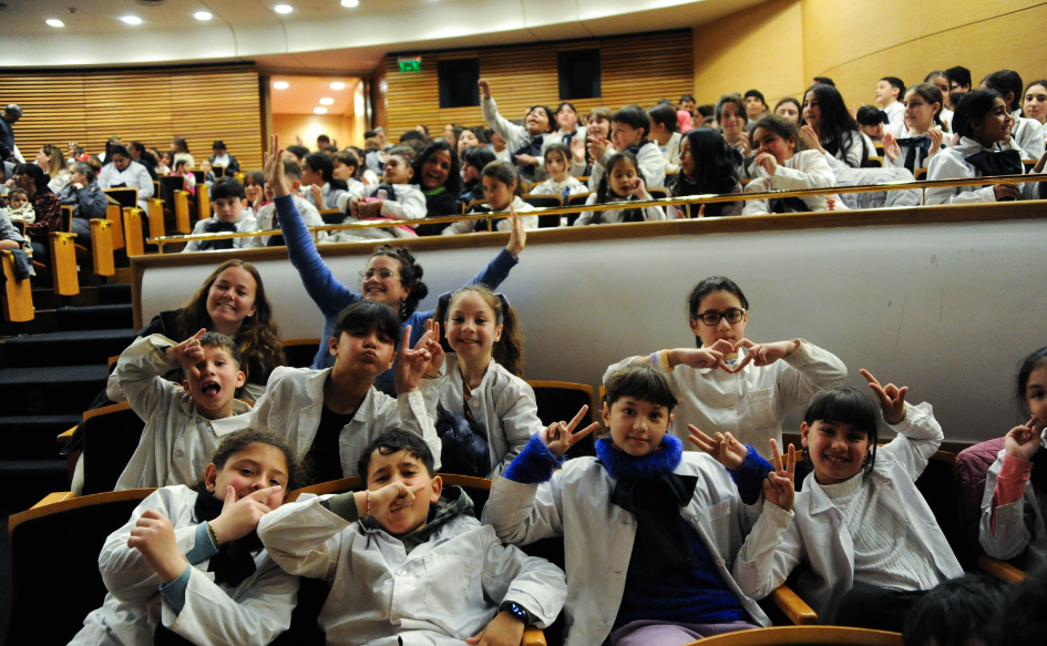Una decena de niños, vestidos con túnica y moña, saludan a la cámara en el Auditorio Nacional Adela Reta, durante la primera edición del programa Infancias al Teatro