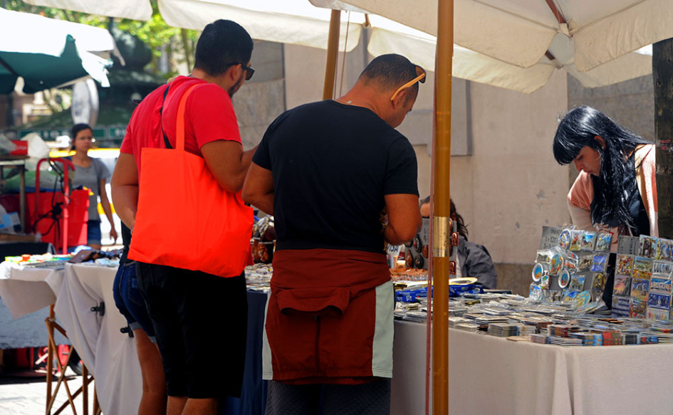Sistema Nacional de Turismo Social busca extender acceso al turismo Dos hombres observan artesanías en un puesto de feria