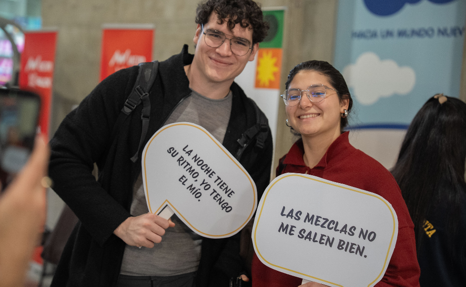 Noche de la Nostalgia: autocuidado y prevención para un disfrute responsable Dos jóvenes muestran a la cámara carteles con frases durante la jornada de sensibilización de la Secretaría Nacional de Drogas en el MAM. Uno dice "La noche tiene su ritmo, yo tengo el mío", y el otro, "Las mezclas no salen bien"