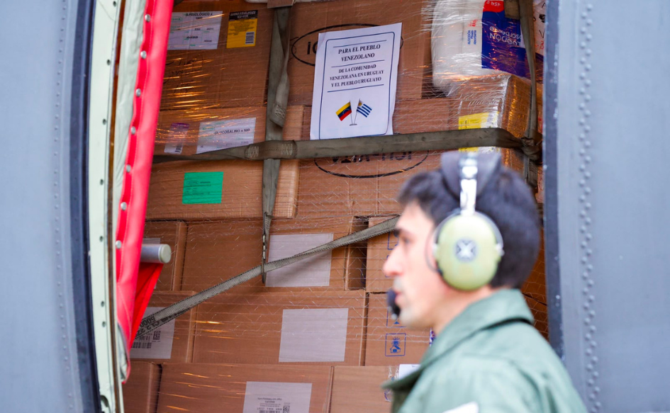 Partió primer vuelo de Uruguay con ayuda humanitaria hacia Venezuela Funcionario de la Fuerza Aérea Uruguaya camina por delante del avión Hércules, en el que se ven cajas con insumos de ayuda humanitaria