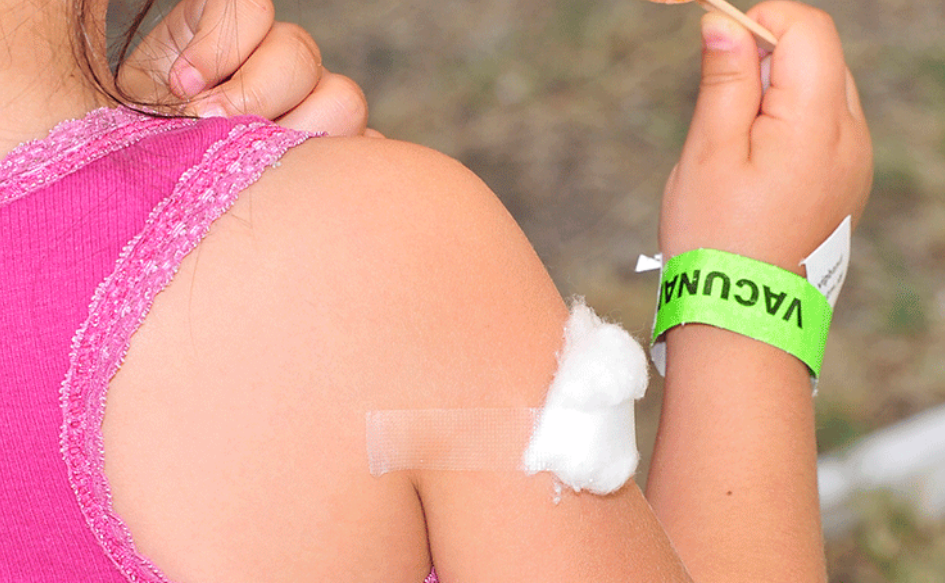 Brazo de una niña con un algodón, tras vacunarse