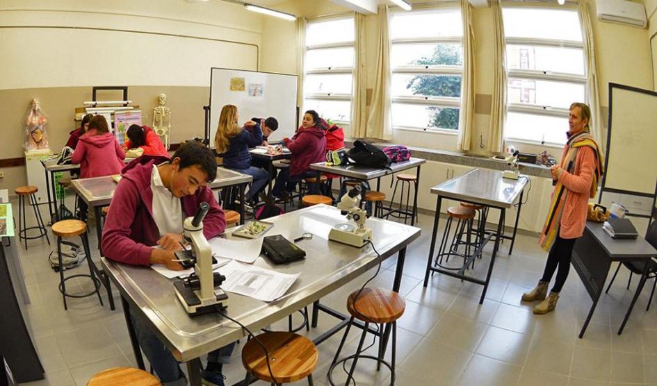 Estudiantes y docente trabajan en un aula laboratorio Estudiantes y docente trabajan en un aula laboratorio