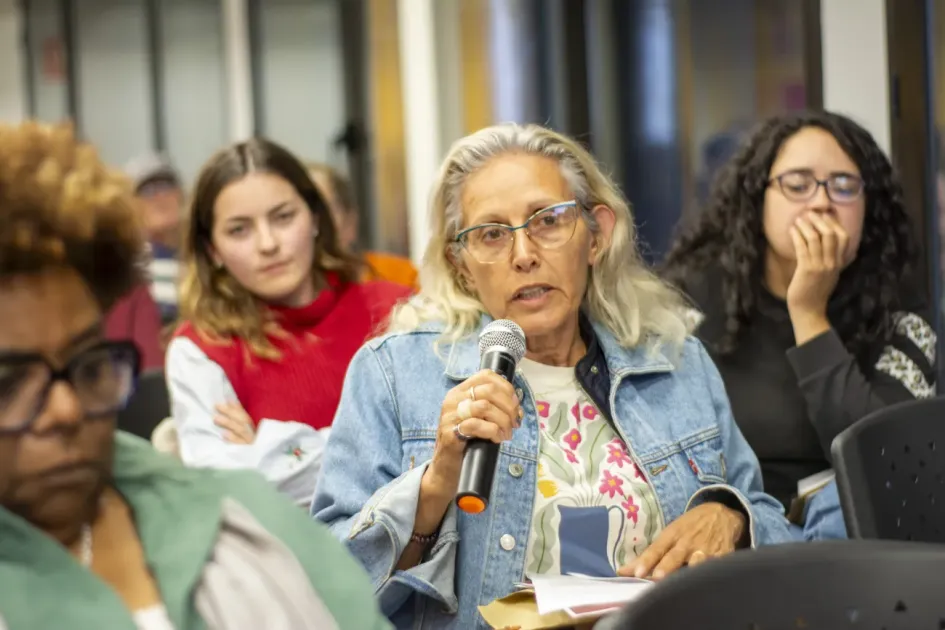 Mujer habla por micrófono en un conversatorio del Diálogo Social
