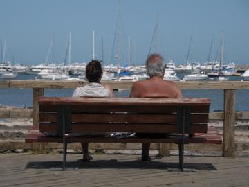 Personas adultas mayores sentadas mirando la rambla