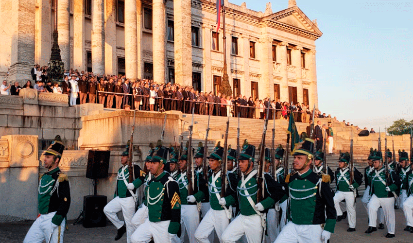 Martín Lema, José Mujica y parlamentarios al pie del Palacio Legislativo observan el desfile del batallón Florida