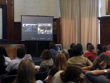 Público mirando videoconferencia Público mirando videoconferencia