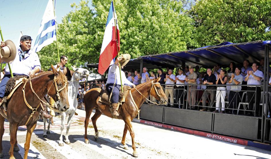 Representantes de una de las aparcerías pasan a caballo y saludan al Presidente Luis Lacalle Pou que se encuentra en el palco oficial