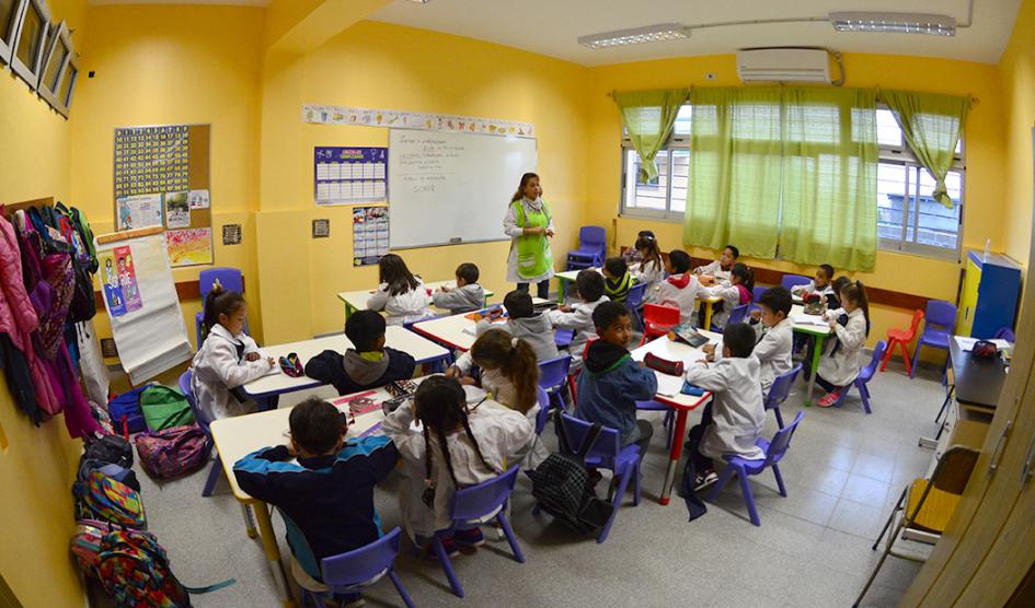 Salón de clases con alumnos y maestra