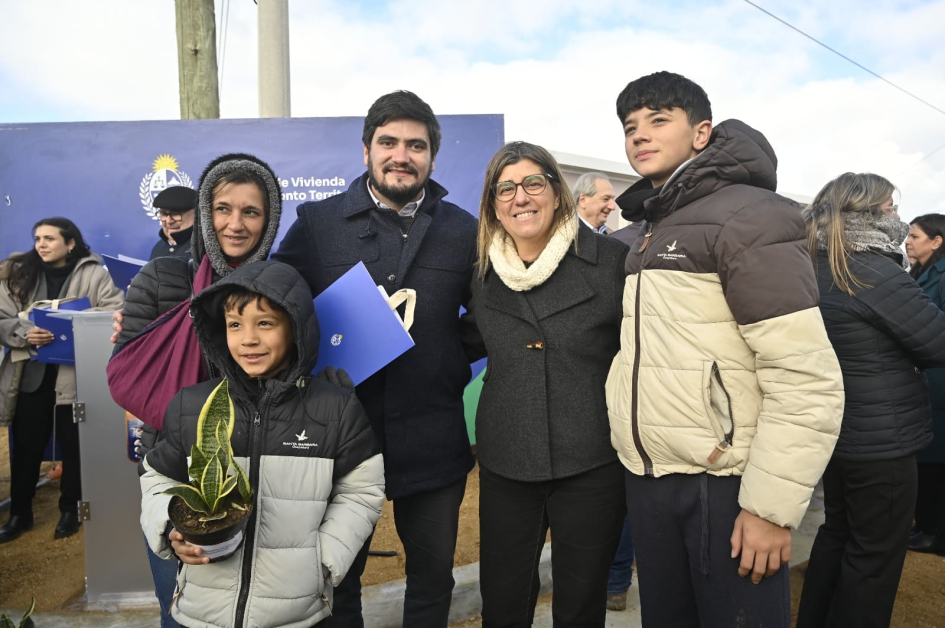 Tamara Paseyro y Pablo Cresci con familias beneficiadas en el barrio Los Eucaliptus, Maldonado