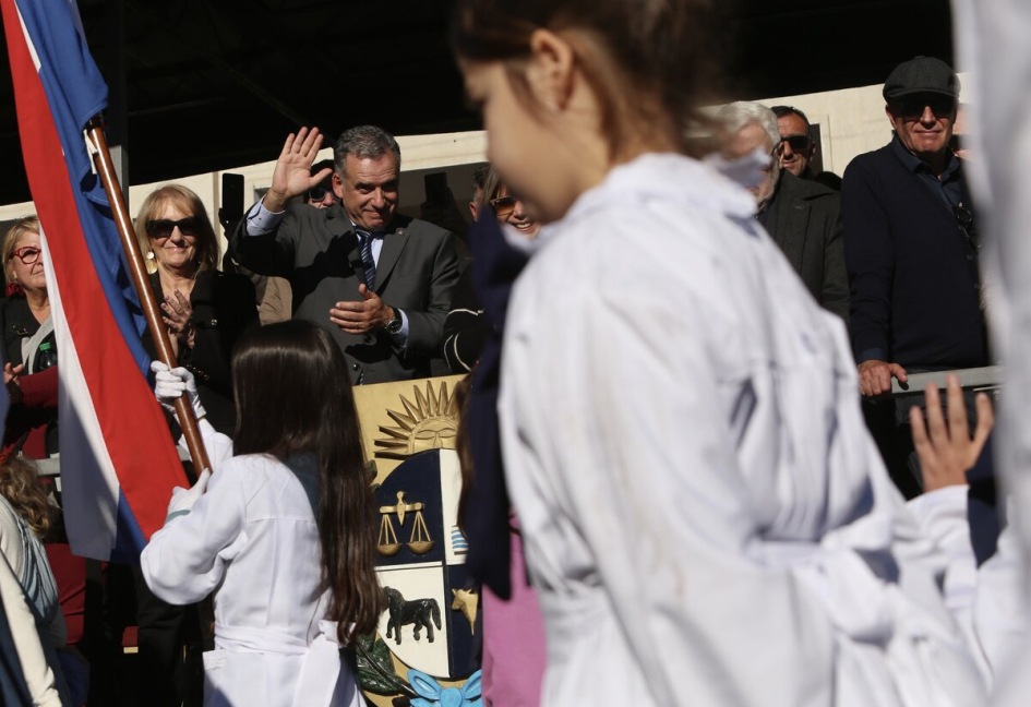 Presidente Orsi y vicepresidenta Cosse desde el palco, saludando y aplaudiendo a escuela desfilando