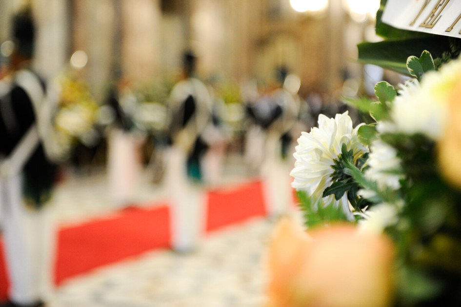 Flor en primer plano, con el fondo difuminado del féretro y la guardia de honor Flor en primer plano, con el fondo difuminado del féretro y la guardia de honor
