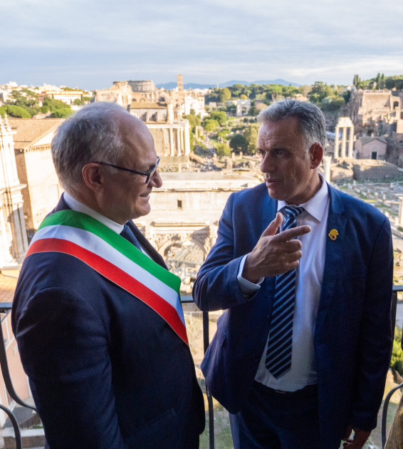 Presidente Orsi dialogando con el alcalde de Roma en un balcón, con la ciudad a sus espaldas
