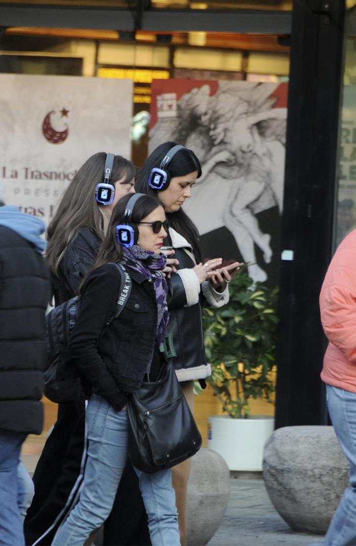 Personas caminan con auriculares