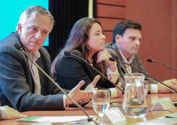 Coordinador de Descentralización de OPP diserta en mesa con micrófono en el auditorio.