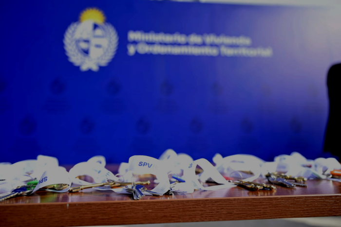 Varias llaves con cintas blancas sobre una mesa. En el fondo cartel azul con el logo del Ministerio.