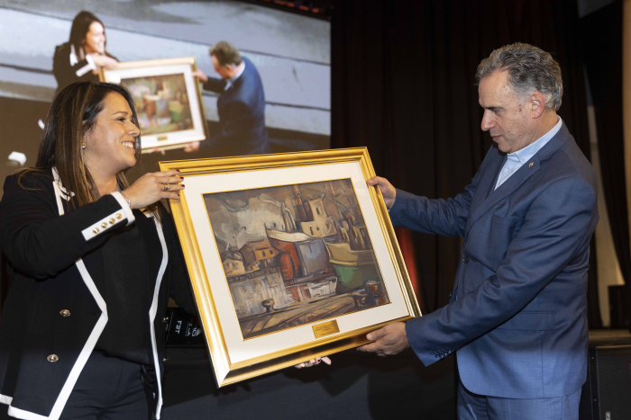 Presidente Orsi y presidenta de Cennave sostienen un cuadro. 