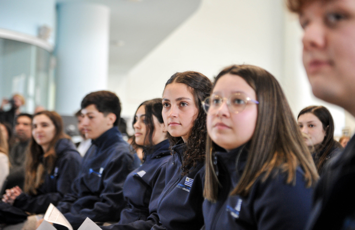 Delegación de estudiantes con uniformes azules sentados en la sala de conferencias de la ANEP.